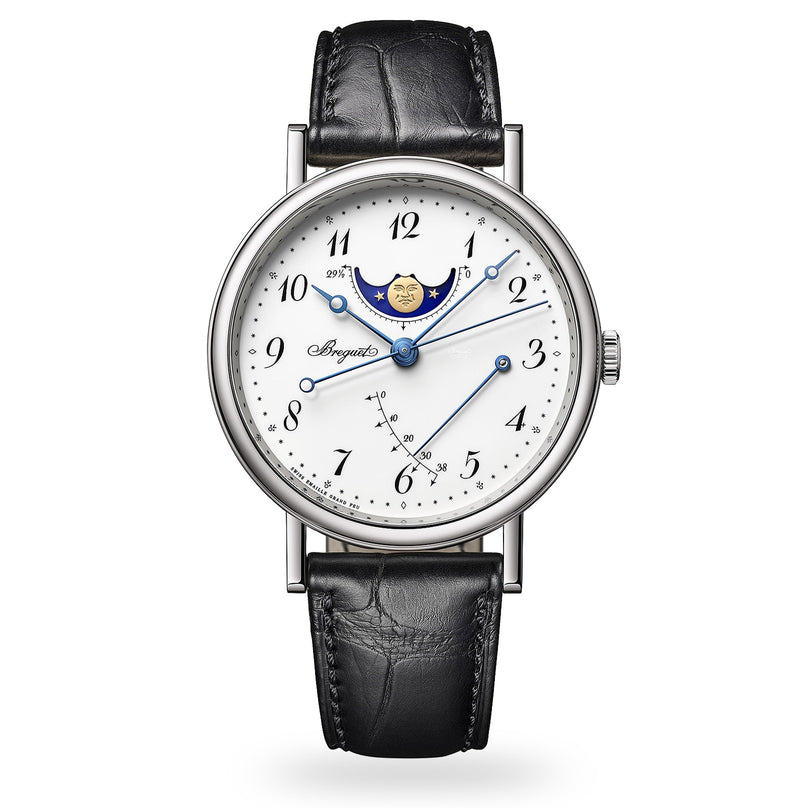 The Breguet Classique Phase de Lune 7787 features a white dial with Arabic numerals, blue hands, moon phase, power reserve indicator, and a black leather strap—showcasing Breguet’s timeless watchmaking style.