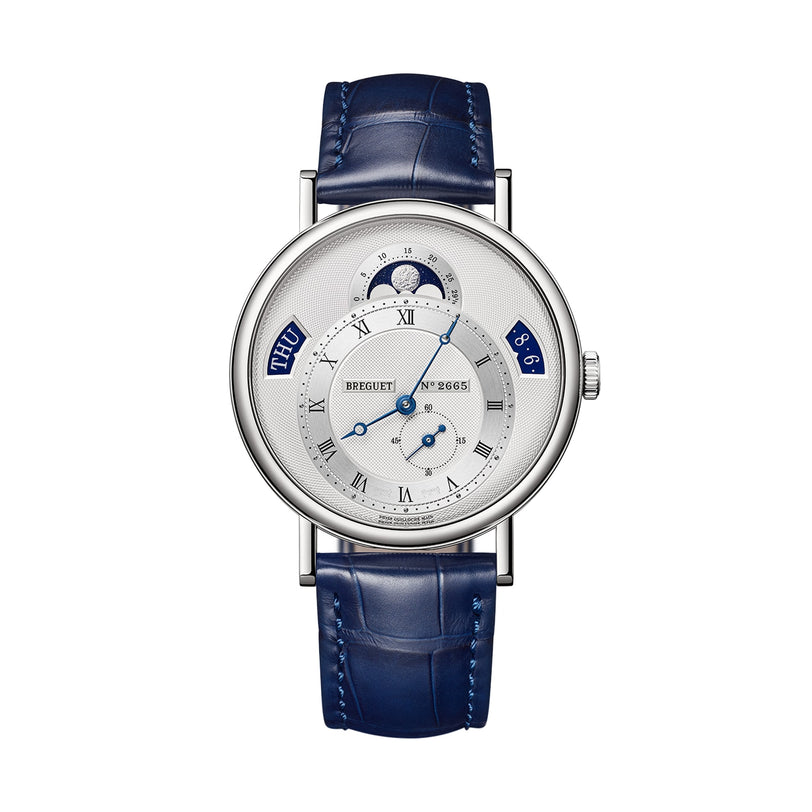The Breguet Classique Calendrier 7337 is a silver watch with a blue leather strap, Roman numeral dial, moon phase display, and day/date windows—an elegant timepiece shown on a white background.