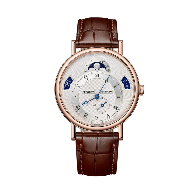 The Breguet Classique Calendrier 7337 is a luxury wristwatch in 18-carat gold featuring a brown leather strap, silver dial, blue hands, Roman numerals, and subdials for day, date, and moon phase with a precise selfwinding movement.