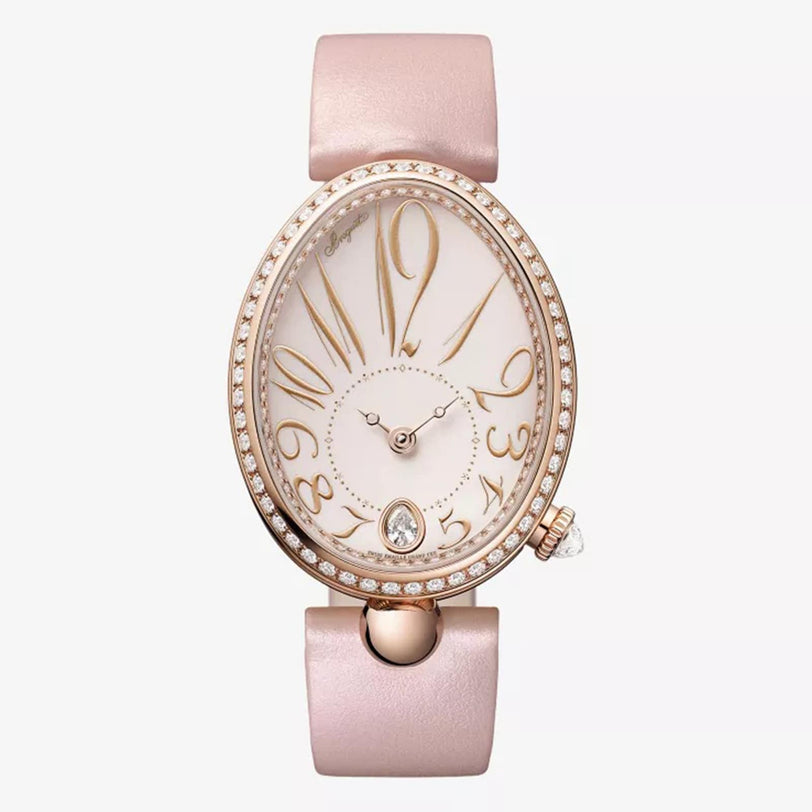 The Breguet Reine de Naples 8918 is an elegant watch with an oval, diamond-encrusted face, gold-tone numerals, a light pink leather strap, and off-center crown—perfect for showcasing feminine refinement.