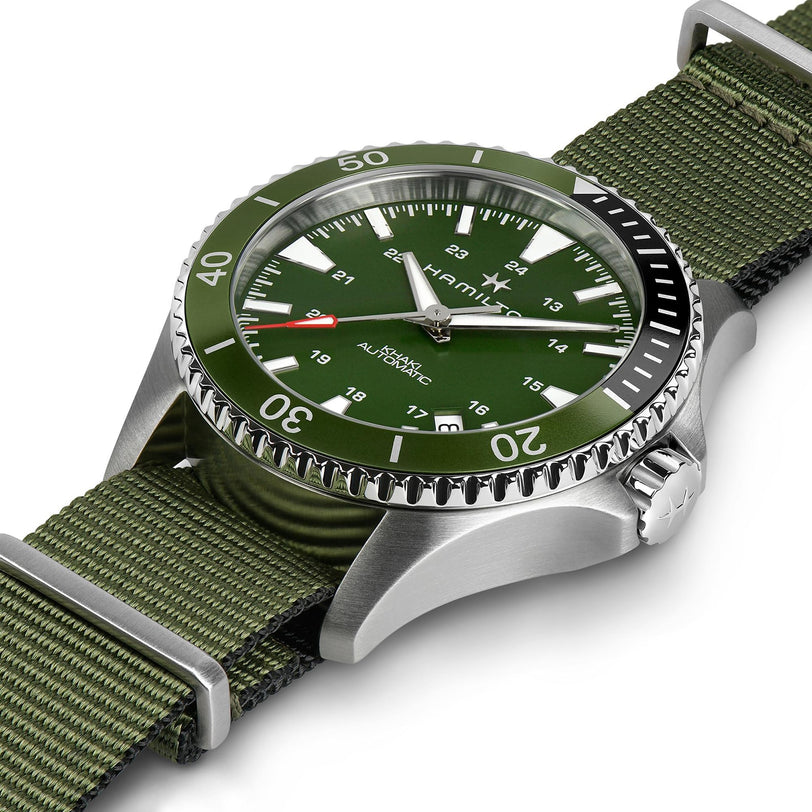 The Hamilton Khaki Navy Scuba Auto features a green dial, Swiss movement, green NATO strap, stainless steel case, rotating bezel, and white hour markers—crafted for a bold nautical style and shown on a white background.