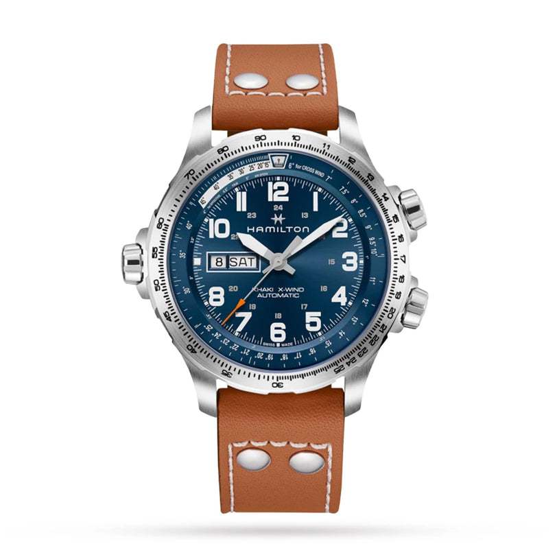 The Hamilton Khaki Aviation X-Wind Day Date Auto features a blue dial with white numerals, automatic Day Date function, SuperLumiNova accents, and a brown leather strap with metal rivets.