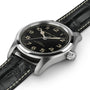 The Hamilton Khaki Field Murph Auto wristwatch features a black dial with Arabic numerals, silver case, and black leather strap with white stitching—an ideal collector’s item inspired by the iconic Interstellar watch.