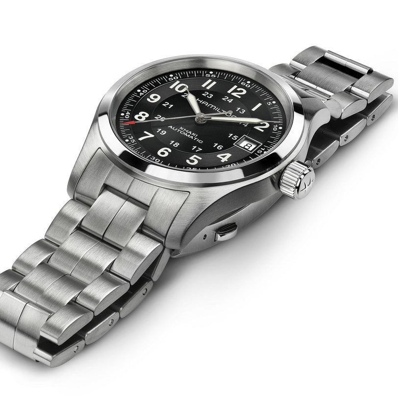 The Hamilton Khaki Field Auto wristwatch, featuring a stainless steel case, black dial with white numerals, and metal link bracelet, is displayed at an angle with its military-inspired design.