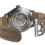 Close-up of the back of a Hamilton Khaki Field Titanium Auto, showcasing its automatic movement through a transparent caseback and a beige leather strap with Hamilton engraved on the buckle.