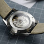 Close-up of the Hamilton Khaki Field Murph 38mms transparent case back reveals its automatic movement, visible gears, engraved details, and notable 80-hour power reserve.