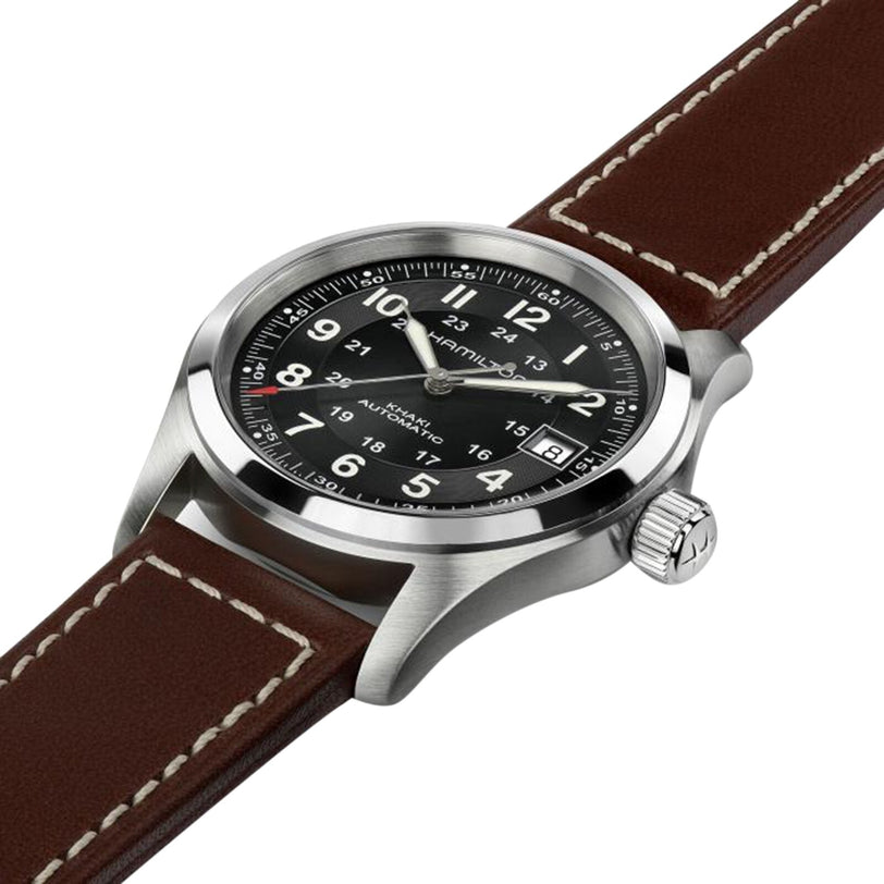 The Hamilton Khaki Field Auto wristwatch features a black dial with white numerals, a silver case and strap, and a brown leather band with white stitching, displayed at an angle.