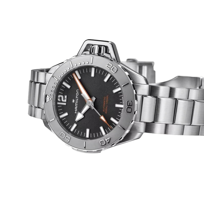 The Hamilton Khaki Navy Frogman Auto, showcased at an angle on its stainless steel bracelet, features a black dial, silver hour markers, and an orange seconds hand—emphasizing its robust water-resistance.