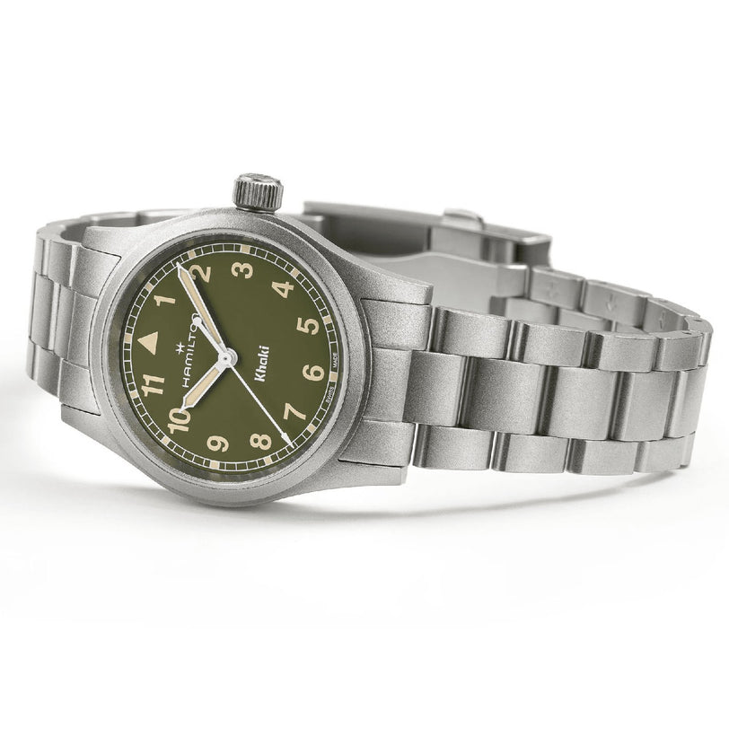 The Hamilton Khaki Field Quartz 33mm features a stainless steel case, olive green dial with Arabic numerals, and Hamilton’s signature above the center. Its brushed metal bracelet reflects the brand’s heritage of precision and adventure.
