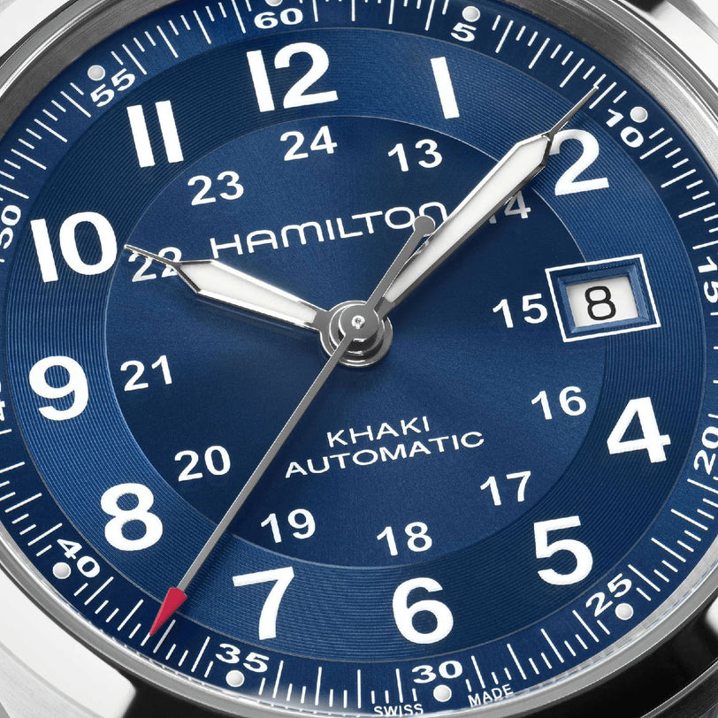 Close-up of the Hamilton Khaki Field Auto 42mms blue dial, featuring hour, minute, and second hands plus a date window at 8—demonstrating its military heritage and precise H-10 automatic movement.