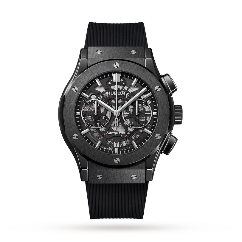The Hublot Classic Fusion Aerofusion Black Magic is a black chronograph with a skeleton dial, visible gears, silver accents, and a black rubber strap set in sleek high-tech ceramic.