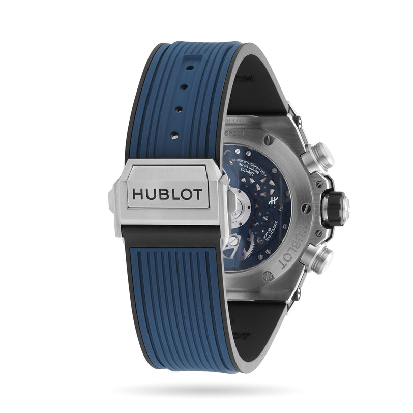 Rear view of a Hublot Big Bang Unico Titanium Blue watch with a blue rubber strap, metal clasp engraved with Hublot, titanium case, and visible mechanical movement through the transparent case back.