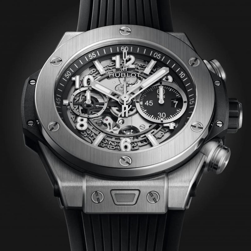 A close-up of the Hublot Big Bang Unico Titanium wristwatch, featuring a skeleton dial, titanium case, visible inner workings, and a black rubber strap.