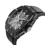 The Hublot Spirit Of Big Bang Black Magic is a black, rectangular luxury skeleton watch with a visible mechanical movement, metal screws on its ceramic case, and a black rubber strap.
