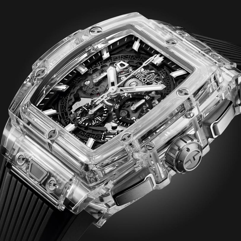 The Hublot Spirit Of Big Bang Magic Sapphire is a transparent luxury wristwatch with a visible mechanical movement and a black rubber strap.