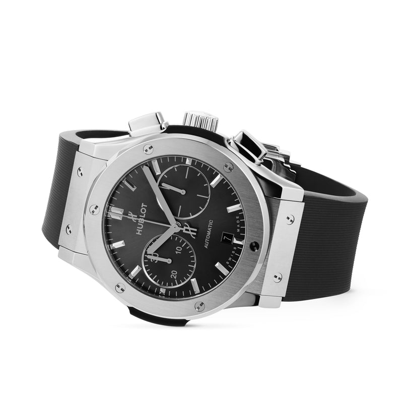 The Hublot Classic Fusion Racing Grey Chronograph Titanium, featuring a titanium case, black dial with chronograph and date display, and a black rubber strap, is displayed on a white background.