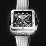 A close-up of the Hublot Square Bang Unico White Ceramic, showcasing a white ceramic case, skeleton dial with visible Unico movement gears, chronograph subdials, and a white textured strap.