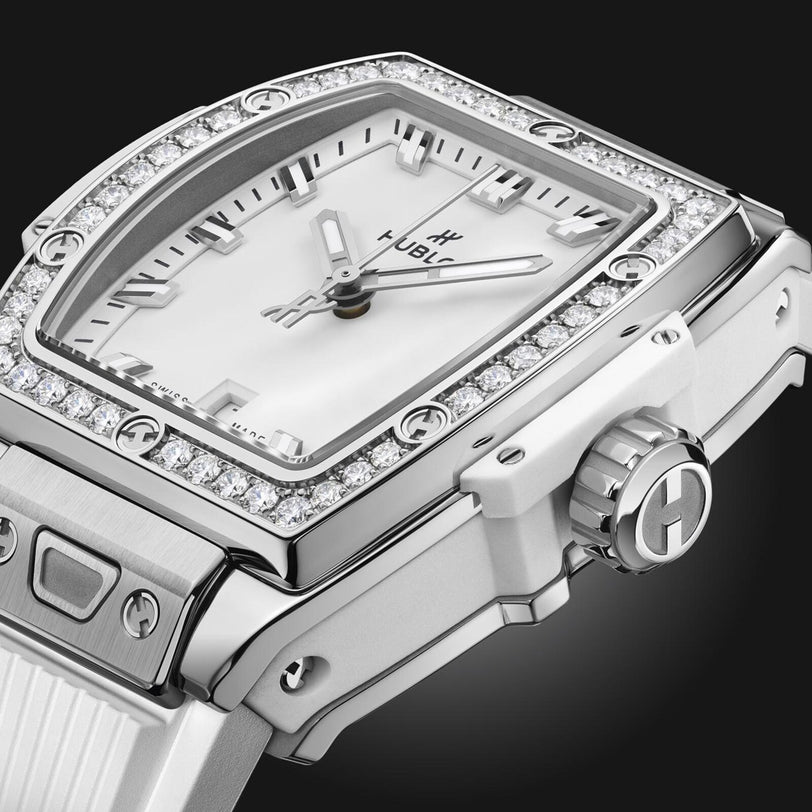 Close-up of the Hublot Spirit Of Big Bang Steel White Diamonds watch, featuring a white face, diamond bezel, and white strap against a black background.
