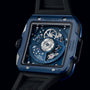 A close-up of the Hublot Square Bang Unico Blue Ceramic watch’s back displays its exposed HUB1280 UNICO mechanical movement and detailed gears beneath a sapphire crystal dial.