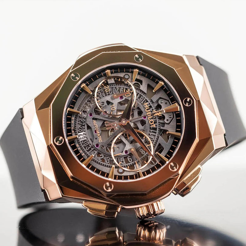 A close-up of the Hublot Classic Fusion Aerofusion King Gold wristwatch featuring a rose gold geometric case, skeleton dial, and black rubber strap, exemplifying modern luxury with its intricate internal mechanics.