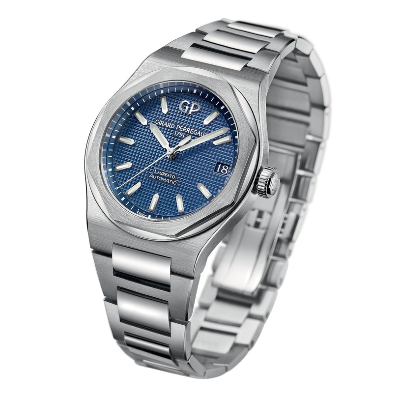 The Girard-Perregaux Laureato 42 is a stainless steel watch with an octagonal bezel, blue textured dial, silver hour markers, date at 3 o’clock, and a metal link bracelet.