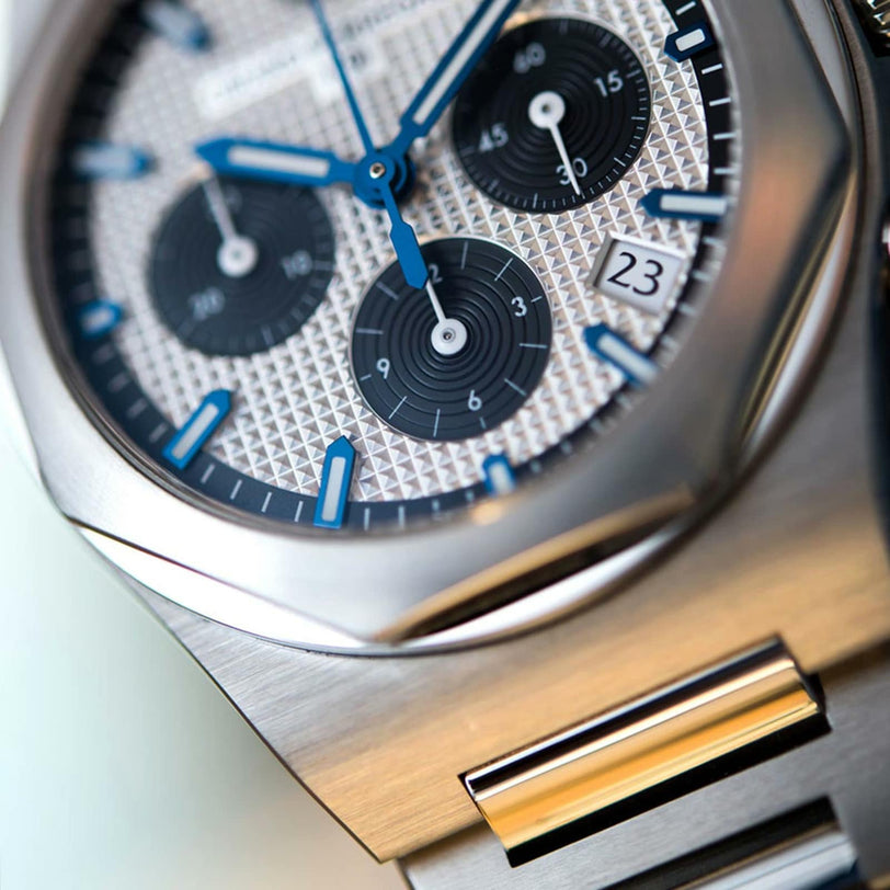 Close-up of the Girard-Perregaux Laureato Chronograph 42, featuring a stainless steel case with octagonal bezel, blue hands, three subdials, textured silver dial, date window at 23, and powered by calibre GP03300.