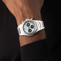 A close-up of the Girard-Perregaux Laureato Chronograph 42, featuring a white dial, three black subdials, and an octagonal bezel, shown on a wrist with a black sleeve.