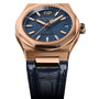 The Girard-Perregaux Laureato 42 features an ultramarine blue textured dial, pink gold case, gold hour markers, a date window at 3 o’clock, and a black leather strap.