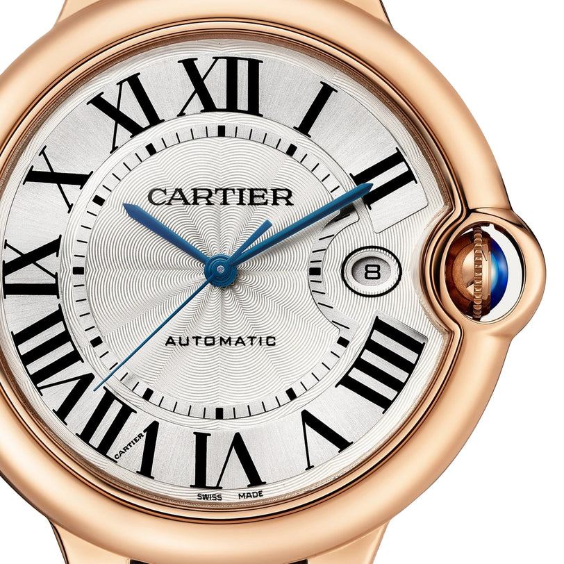 Close-up of the Cartier Ballon Bleu de Cartier watch, featuring Roman numerals, blue hands, date window at 3 o’clock, 18K rose gold case, blue cabochon crown, and self-winding mechanical movement.