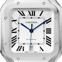 Close-up of the Cartier Santos de Cartier watch face, featuring Roman numeral hour markers, blue hands, and a date window at 6 o’clock with the number 7, powered by a self-winding mechanical movement.