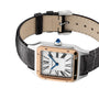 A Cartier Ballon Bleu de Cartier watch featuring a round case, Roman numerals, blue hands, a gold bezel, black leather strap, and a blue gemstone set into the crown.