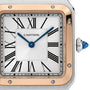 Close-up of a Ballon Bleu de Cartier watch face with Roman numerals, blue hands, gold accents on the round bezel, and a crown set with a blue cabochon—a signature detail of Cartier’s iconic Ballon Bleu collection.
