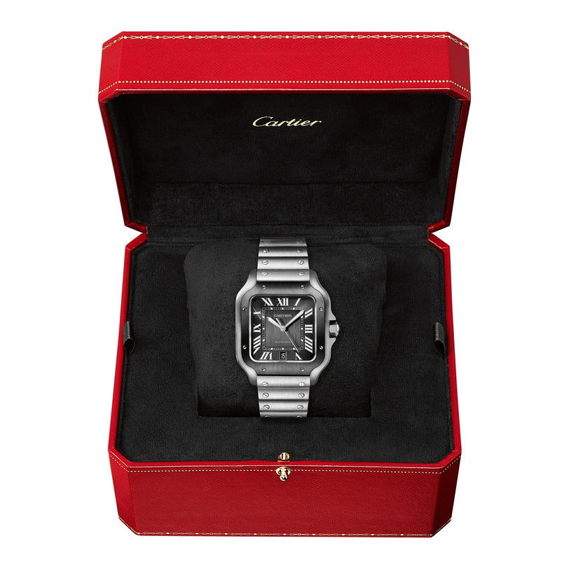 A Cartier Santos de Cartier stainless steel watch with automatic movement and black dial, shown in an open red Cartier box lined with black fabric.