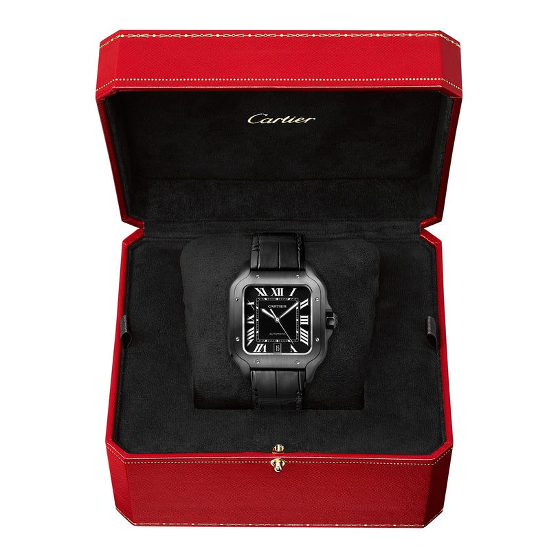 The Santos de Cartier watch by Cartier features a black strap, square black face with Roman numerals, and comes displayed in an open red Cartier box lined with black velvet. It includes the QuickSwitch system for easy strap changes.