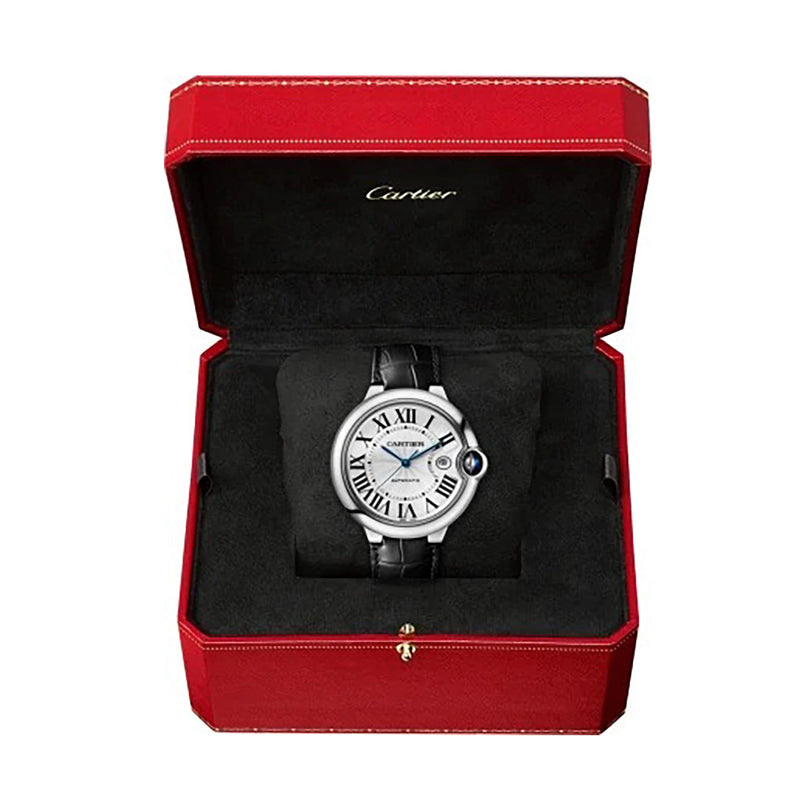 A Ballon Bleu de Cartier watch by Cartier, featuring a black leather strap and Roman numerals, is presented in an open red and black Cartier box, exuding elegance.