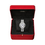 A Ballon Bleu de Cartier watch with a silver-tone case, white dial, and Roman numerals is displayed in an open red Cartier box with a black interior.