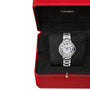 A Ballon Bleu de Cartier wristwatch with a round face and Roman numerals sits in an open red Cartier box, its elegant steel case highlighted against the black interior.