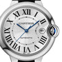 Close-up of a Cartier Ballon Bleu de Cartier automatic watch with a silver dial, Roman numerals, blue hands, date at 3 o’clock, crown set with blue cabochon, interchangeable bracelet, and signature mechanical movement.