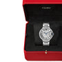 The Ballon Bleu de Cartier wristwatch by Cartier, with a round silver face and Roman numerals, is shown in an open red Cartier box with black interior and includes a steel interchangeable bracelet for versatile style.