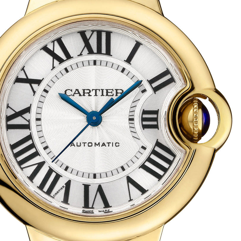Close-up of the Cartier Ballon Bleu de Cartier watch featuring an automatic movement, yellow gold bracelet, Roman numeral markers, blue hands, and a sapphire cabochon crown.