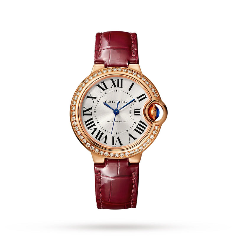 The Ballon Bleu de Cartier watch by Cartier features a round, diamond-set rose gold bezel, Roman numerals, and a burgundy leather strap, shown against a white background.