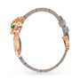 La Panthère de Cartier by Cartier is a bracelet with a rose gold panther head, green gemstone eyes, a brilliant-cut diamond accent, and a thin gray alligator leather strap.
