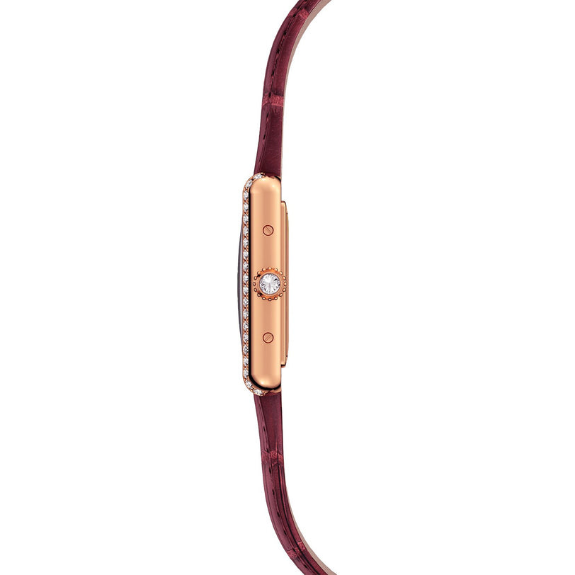 A slim, rose gold Cartier Tank Louis Cartier watch with a diamond-set bezel and a burgundy leather strap, shown in side profile.