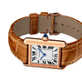 The Cartier Tank Louis Cartier is a rectangular rose gold watch with a brown alligator strap, white dial featuring Roman numerals and blue hands, shown against a white background.