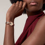 Woman wearing a sleeveless burgundy top and the elegant La Panthère de Cartier gold wristwatch by Cartier.