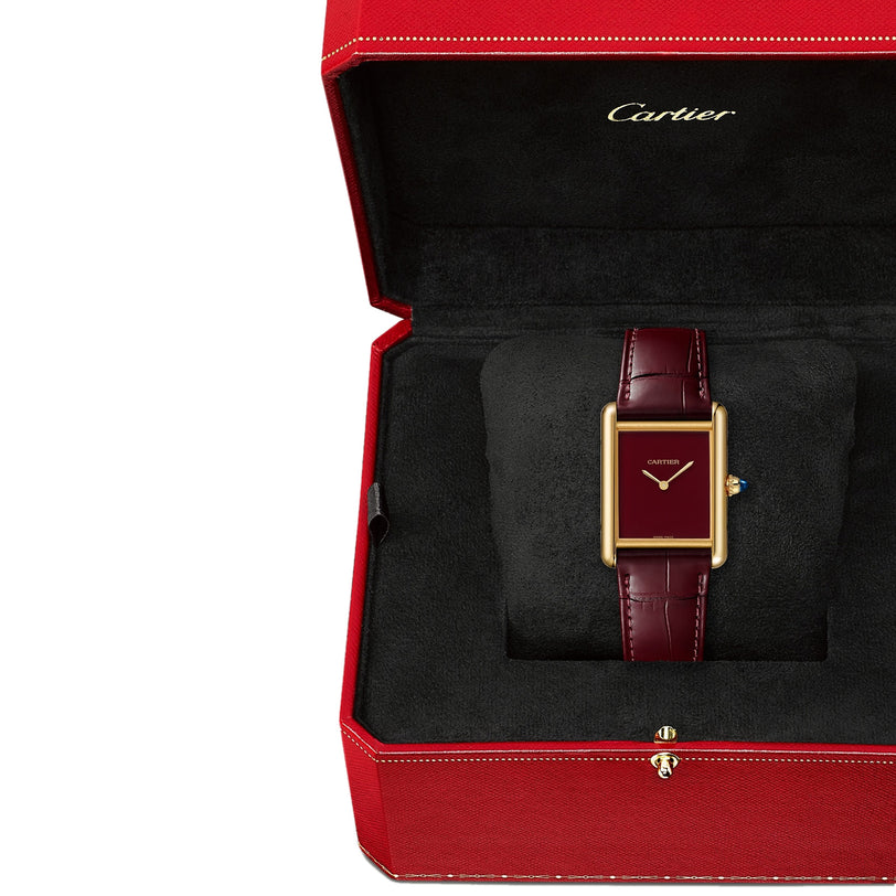 The Cartier Tank Louis Cartier wristwatch, featuring a burgundy leather strap and 18K yellow gold case, is elegantly presented in an open red Cartier box.