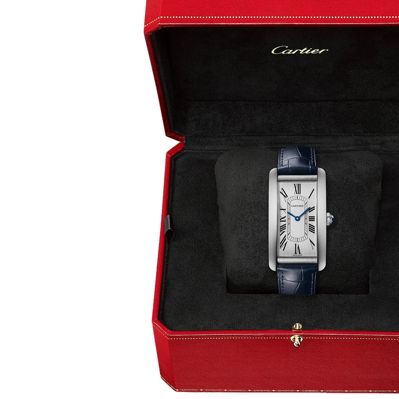 A Cartier Tank Américaine watch with a blue leather strap is presented in an open red Cartier box with black interior, showcasing timeless elegance.
