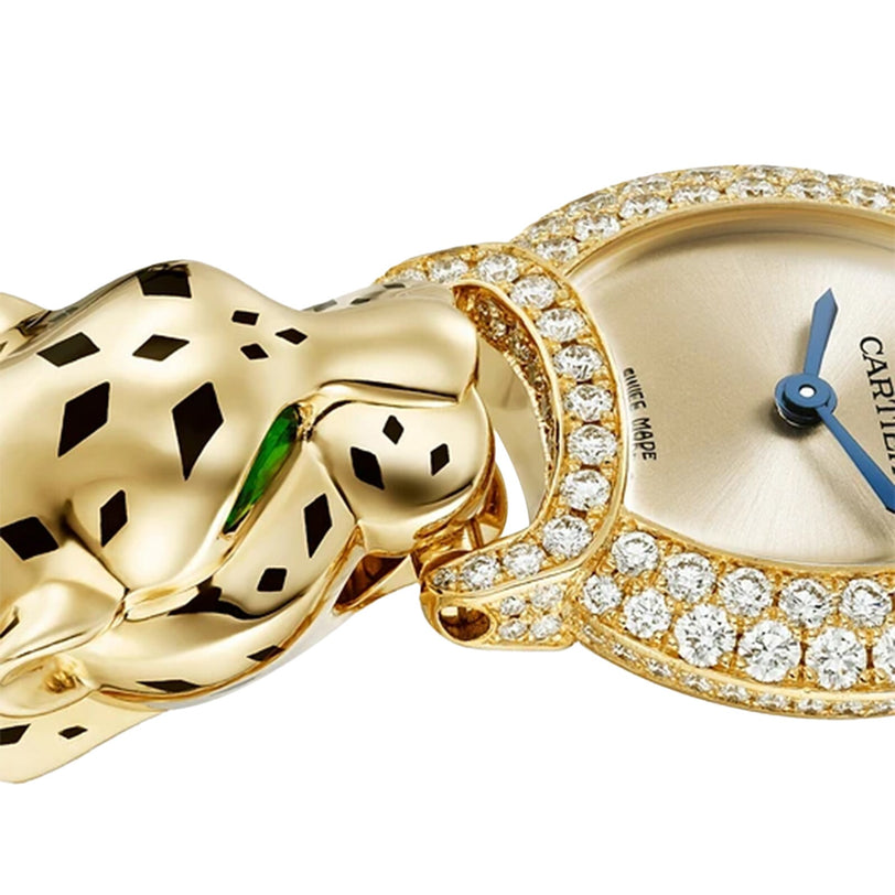 Close-up of Cartier’s La Panthère de Cartier watch in yellow gold, showcasing a brilliant-cut diamond-set bezel and a panther head motif with black spots and vivid green eyes.