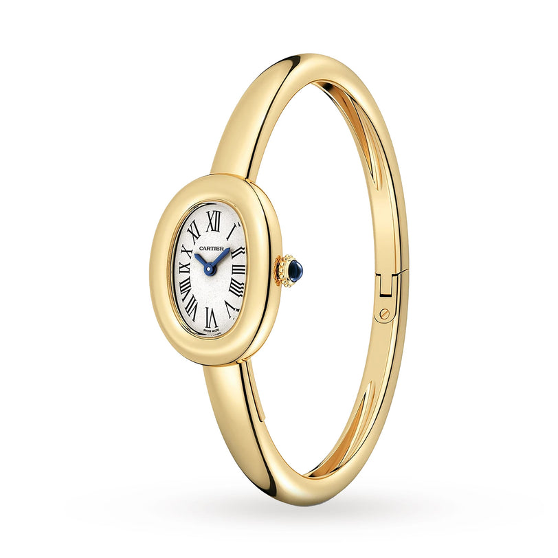 The Cartier Baignoire (Size 15) is an oval yellow gold bangle watch featuring a white dial with Roman numerals, blue hands, quartz movement, and a blue gemstone on the crown.