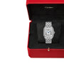 The Panthère de Cartier, a silver Cartier wristwatch with a rectangular face and Roman numerals, is displayed in a red Cartier box with a black velvet interior.